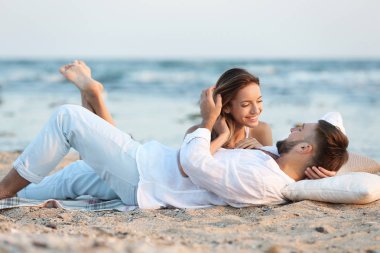 Genç çift kumsalda birlikte vakit geçiriyor.