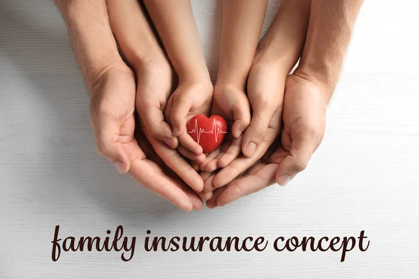 保険の概念 幸せな家族に赤いハートを保持手明るい背景 トップ ビュー — ストック写真