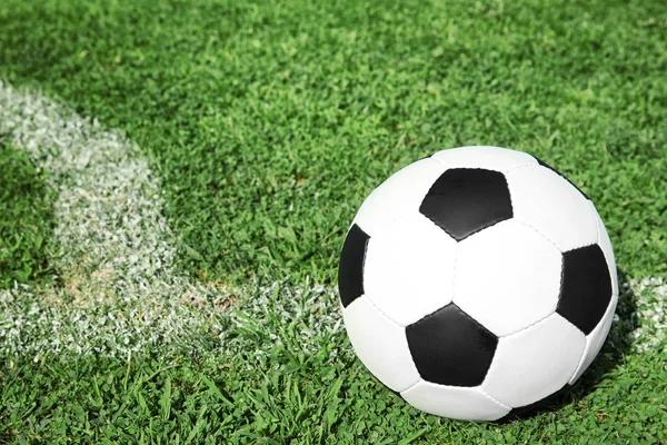 Taze yeşil futbol alanı çimenlerin üzerinde futbol topu. Metin için yer