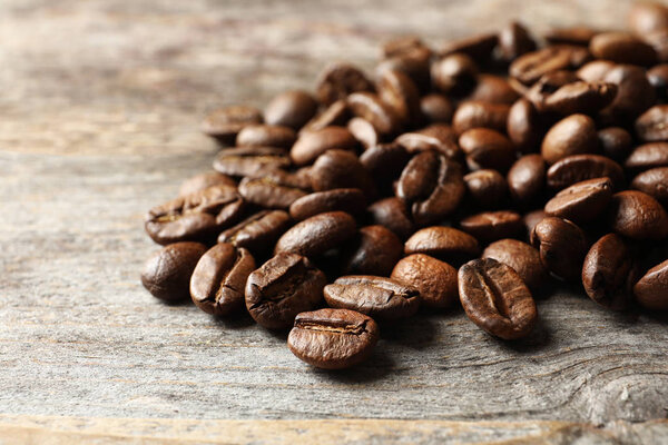 Roasted coffee beans on wooden background, closeup