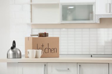 Kutusu, dishware ve yapışkan bant dağıtıcı masada kapalı hareket. Metin için yer
