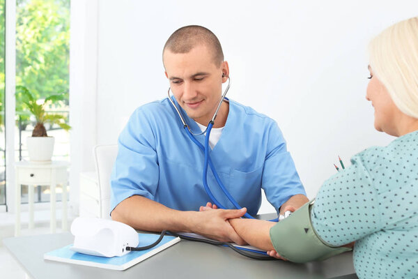Male medical assistant consulting female patient in clinic