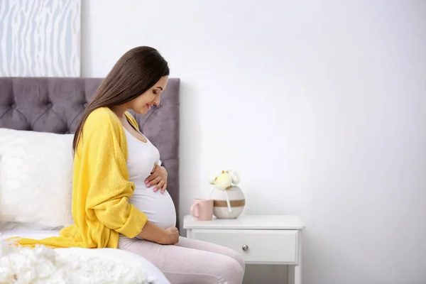 Jovem Bela Mulher Grávida Sentada Cama Tocando Sua Barriga Casa — Fotografia de Stock