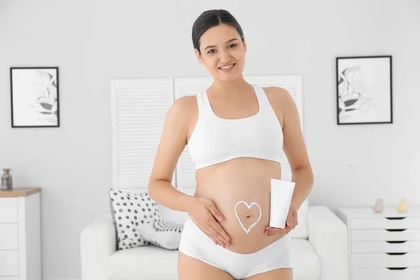 Zwangere Vrouw Met Hart Haar Buik Houden Lichaam Crème Thuis — Stockfoto