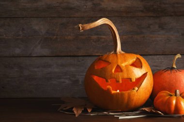 Cadılar Bayramı Balkabağı kafa fener ve sonbahar dekorasyonları ahşap arka plan metin için yer ile karşı masada jack