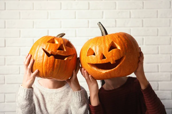 Frauen Mit Halloween Kürbiskopf Stemmen Laternen Gegen Ziegelwand — Stockfoto