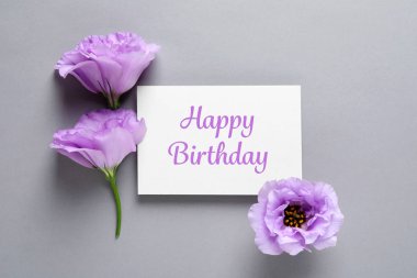Eustoma çiçek ve gri arka plan üzerinde Happy Birthday tebrik ile kart düz yatıyordu kompozisyon
