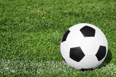 Taze yeşil futbol alanı çimenlerin üzerinde futbol topu. Metin için yer