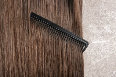 Güzel saç ve tarak gri arka planda, üstten görünüm