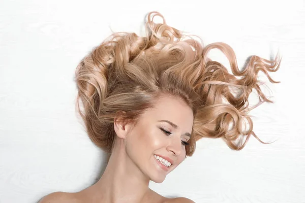 Krásná Žena Zdravými Dlouhými Blonďatými Vlasy Světlé Dřevěné Pozadí Pohled — Stock fotografie