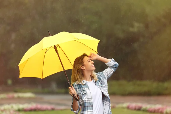 公園で雨の下で傘を持つ幸せな若い女性 — ストック写真