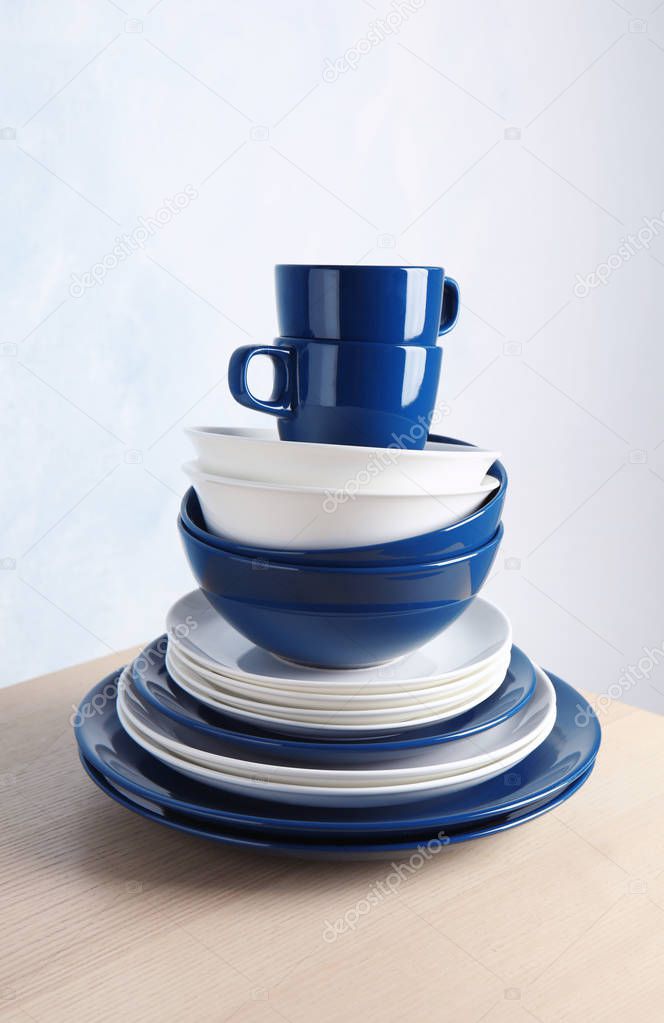 Set of dinnerware on table against light background. Interior element