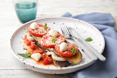 Fırında patlıcan domates, peynir ve ahşap masaya servis fesleğen ile