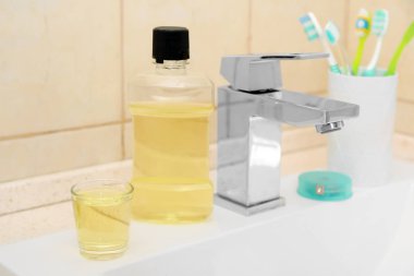 Diş macunu ve diş fırçası ile sahibi içinde banyo lavabo. Diş ve ağız bakımı