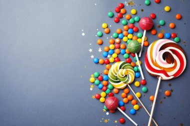 Lolipop ve gri arka plan, üstten görünüm üzerinde renkli şekerler. Metin için yer
