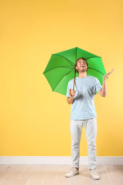 Adam Renk Duvarının Yakınında Yeşil Şemsiye Ile — Stok fotoğraf