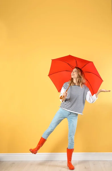 色の壁の近くの赤い傘を持つ女性 — ストック写真
