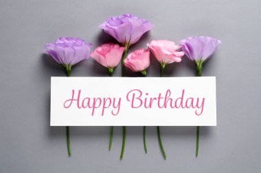 Eustoma çiçek ve gri arka plan üzerinde Happy Birthday tebrik ile kart düz yatıyordu kompozisyon