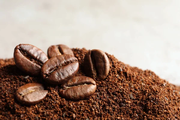 Coffee grounds and roasted beans on table, closeup