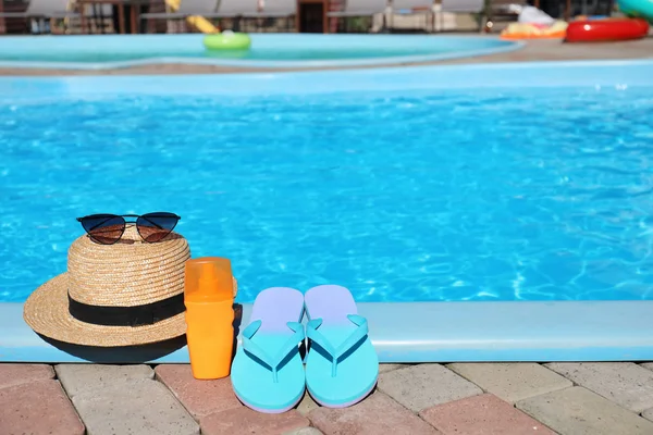 Beach accessories near swimming pool on sunny day. Space for text