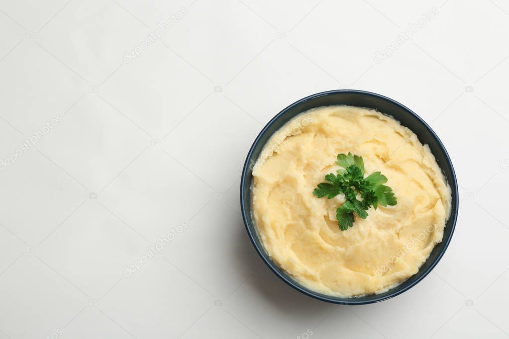 Bowl with tasty mashed potatoes and space for text on white background, top view