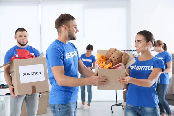 Jovens Voluntários Segurando Caixas Com Doações Dentro Casa — Fotografia de Stock