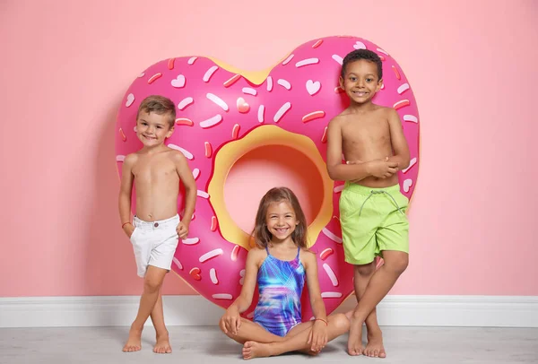 可爱的小孩子与明亮的心脏形状充气圆环在颜色墙壁附近 — 图库照片