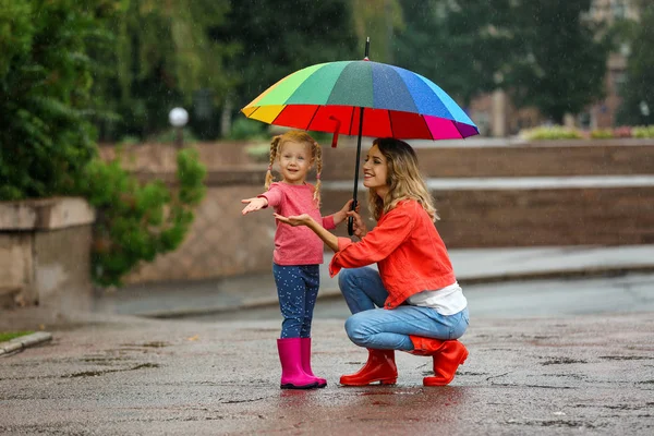 Felice Madre Figlia Con Ombrello Luminoso Sotto Pioggia All Aperto — Foto Stock