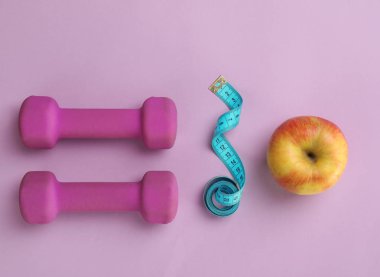 Taze elma, teyp ve renk arka plan, üstten görünüm üzerinde halter ölçme. Sağlıklı beslenme