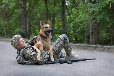 Alman çoban köpeği yolda yalan ile askeri üniformalı erkeklere