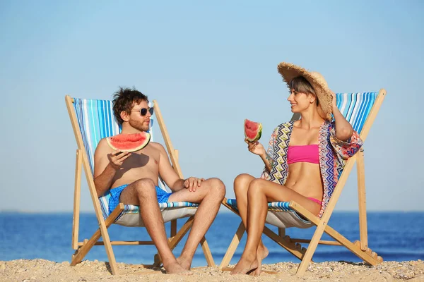 Pareja Joven Con Rodajas Sandía Sillas Playa Costa — Foto de Stock