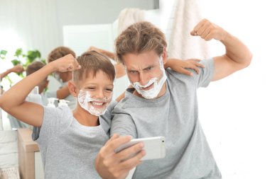 Baba ve oğul selfie tıraş ile alarak banyo yüzleri üzerinde köpük