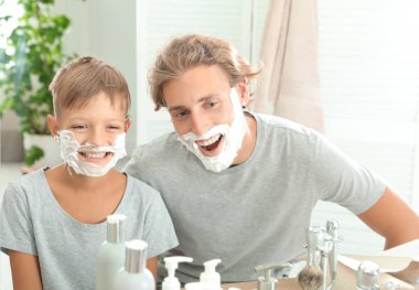 Baba ve oğul banyo yüzleri üzerinde köpük tıraş ile