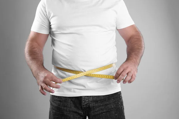 Kövér Ember Szürke Háttér Vértes Mérőszalaggal Fogyás — Stock Fotó