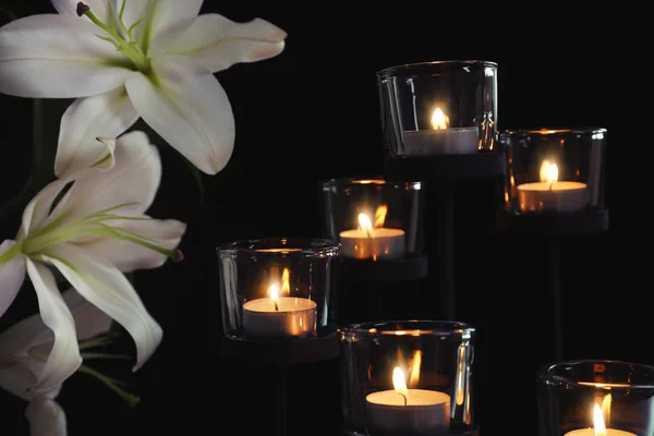 燃える蝋燭と暗い背景の花です 葬儀のシンボル — ストック写真