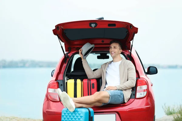 Lycklig Man Sitter Bilen Stammen Med Resväskor Riverside — Stockfoto