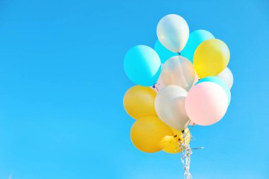 Renkli balonlar karşı grup mavi gökyüzü güneşli günde temizleyin. Metin için yer