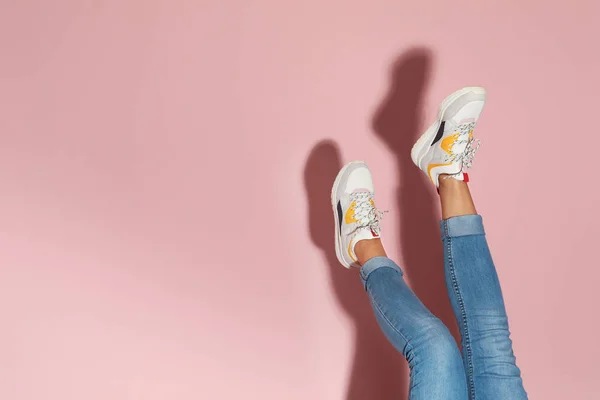 女人在时髦的运动鞋附近彩色墙壁 文本空间 — 图库照片