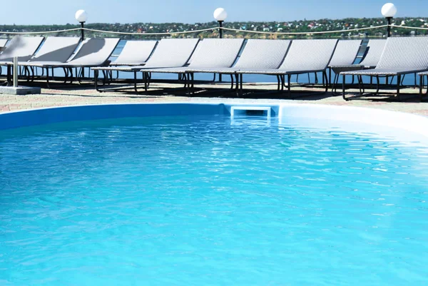 室外游泳池和干净的蓝色水和休闲椅 — 图库照片