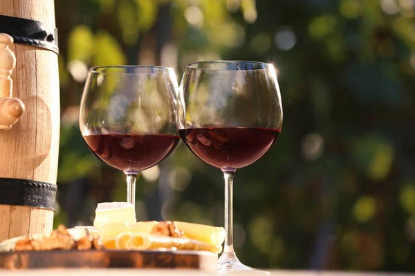 Glasses with red wine on table outdoors. Space for text