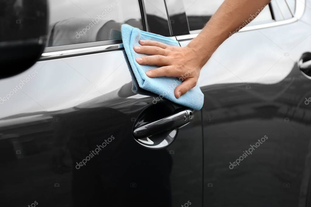 Man washing car door with rag, closeup