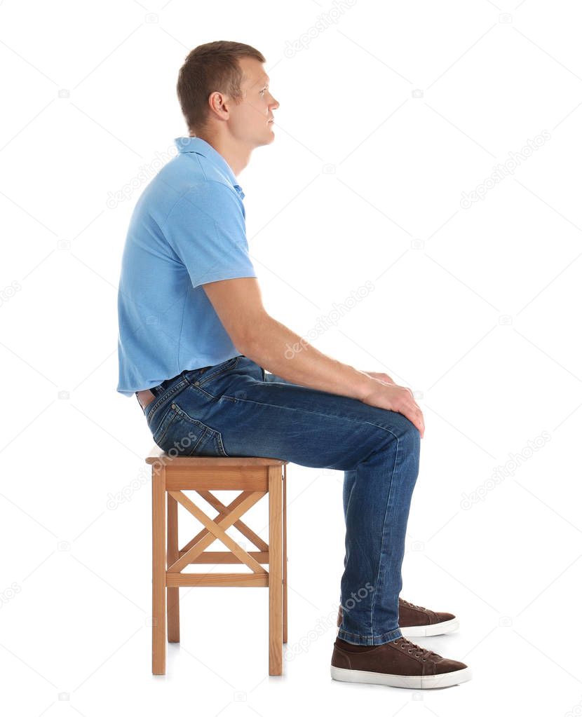 Man sitting on stool against white background. Posture concept