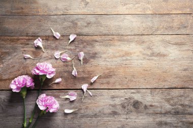 Ahşap arka plan üzerinde güzel çiçek açan çiçekler ile düz yatıyordu kompozisyon