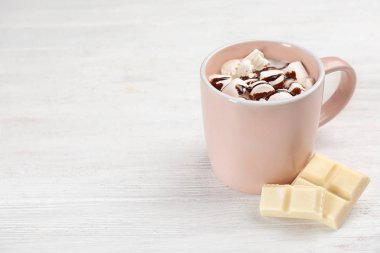Fincan çikolatalı süt ile ışık ahşap arka plan üzerinde marshmallows. Metin için yer