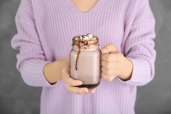 Kvinna Som Håller Burken Med Chokladmjölk Och Marshmallows Grå Bakgrund — Stockfoto