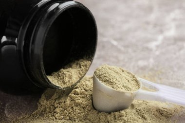 Kavanoz ve kenevir protein tozu masada kaşıkla ölçme