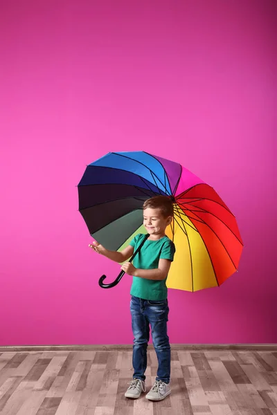 Маленький Мальчик Радужным Зонтиком Возле Цветной Стены — стоковое фото