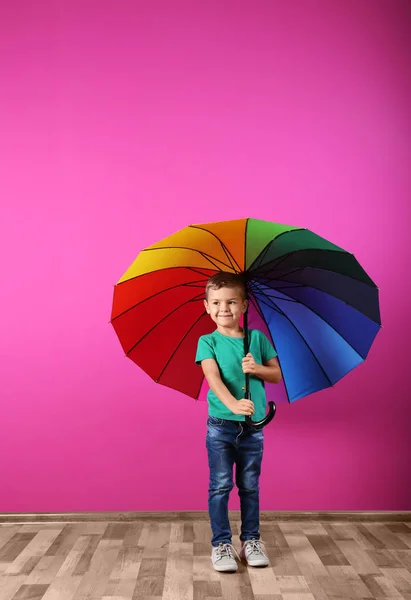 Маленький Мальчик Радужным Зонтиком Возле Цветной Стены — стоковое фото