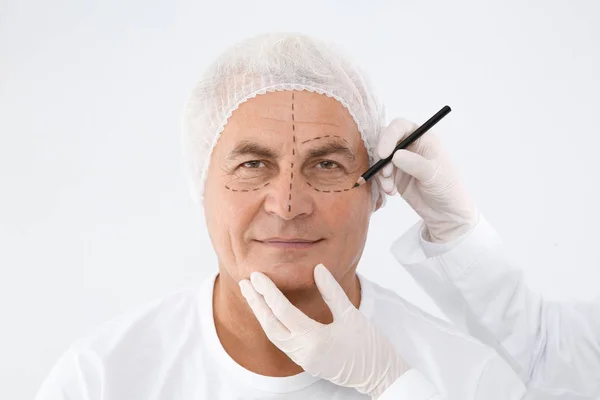 Doutor Marcando Cara Homem Sênior Antes Cirurgia Estética Fundo Branco — Fotografia de Stock