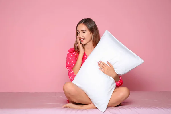 Bella Ragazza Adolescente Abbracciando Cuscino Sul Letto Contro Sfondo Colore — Foto Stock